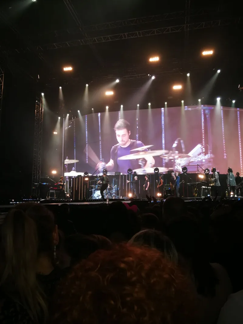 Сценическое фото Biagio Antonacci на большом концерте, вертикальный кадр