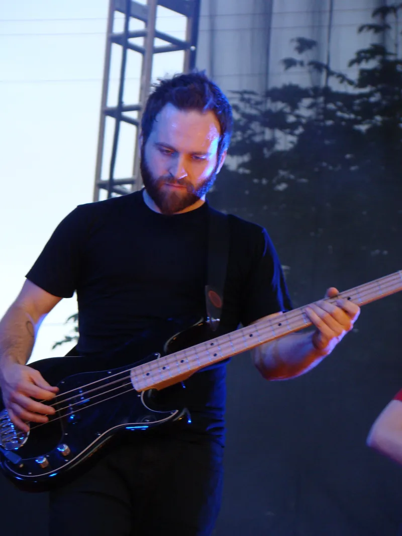 Ник Хармер с бас-гитарой на сцене