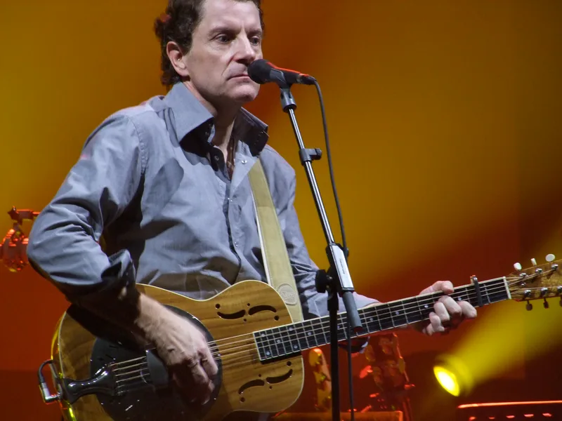 Франсис Кабрель поёт у микрофона с гитарой, концерт в Forest National (Брюссель), 2008