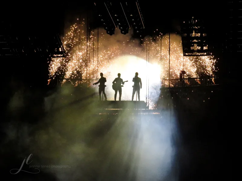 Jonas Brothers на сцене в 2019 году во время тура Happiness Begins, силуэты и пиротехника