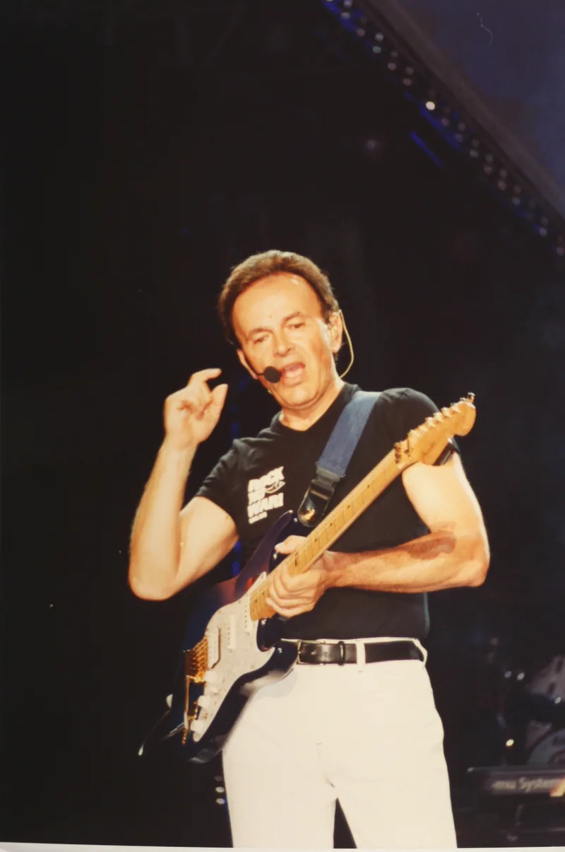 Доди Батталья с электрогитарой во время концертного выступления