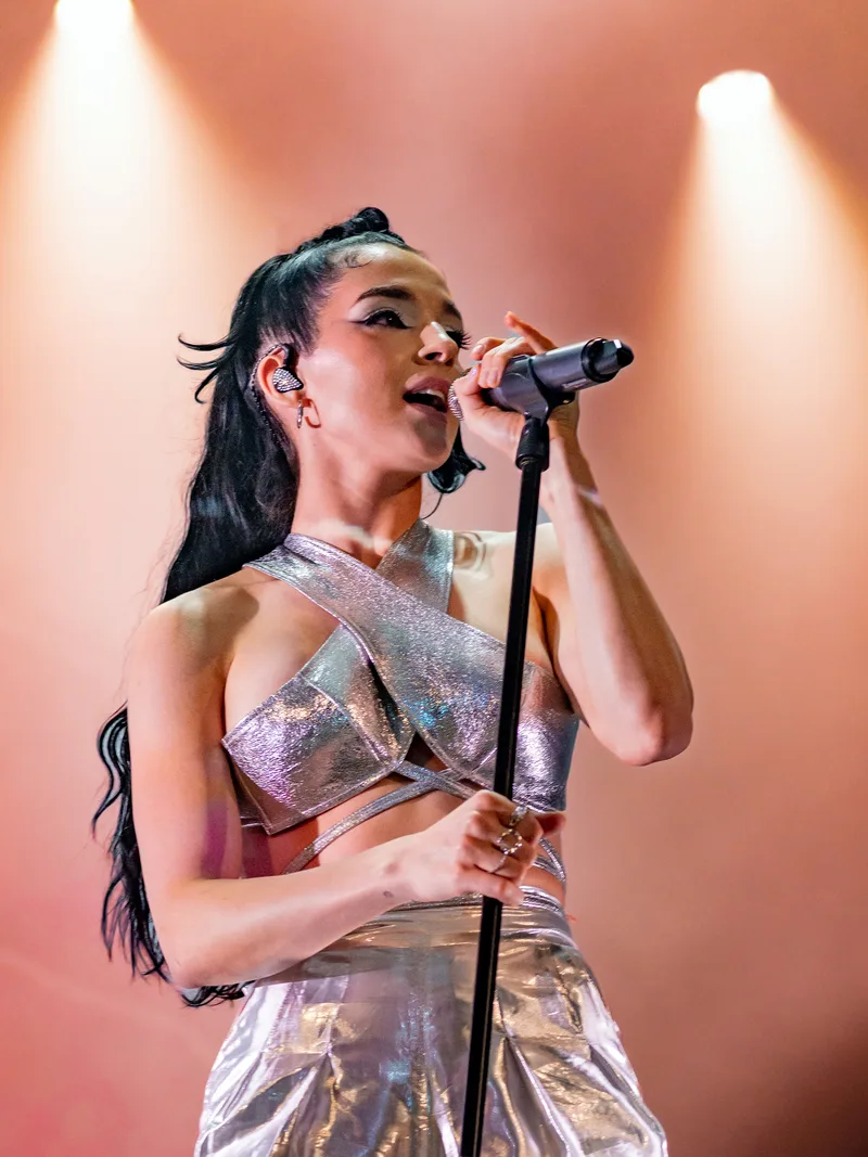 Poppy выступает у микрофона в серебристом костюме