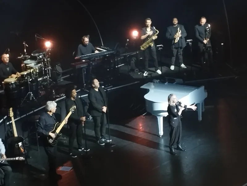 Веро́ник Сансон с группой и белым роялем на сцене, 2024